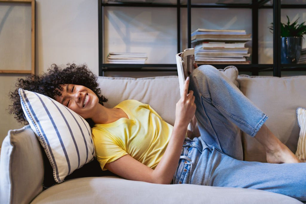 Femme heureuse sur un canapé en faisant la sieste