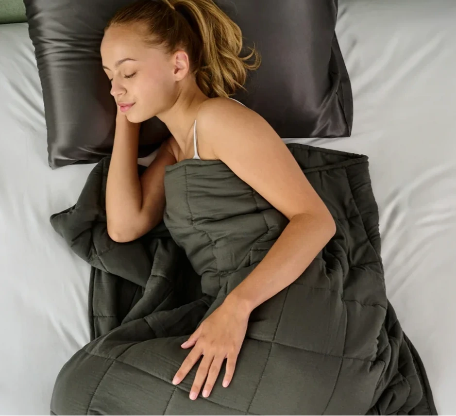 femme dort tranquillement sous une couverture lestée grise