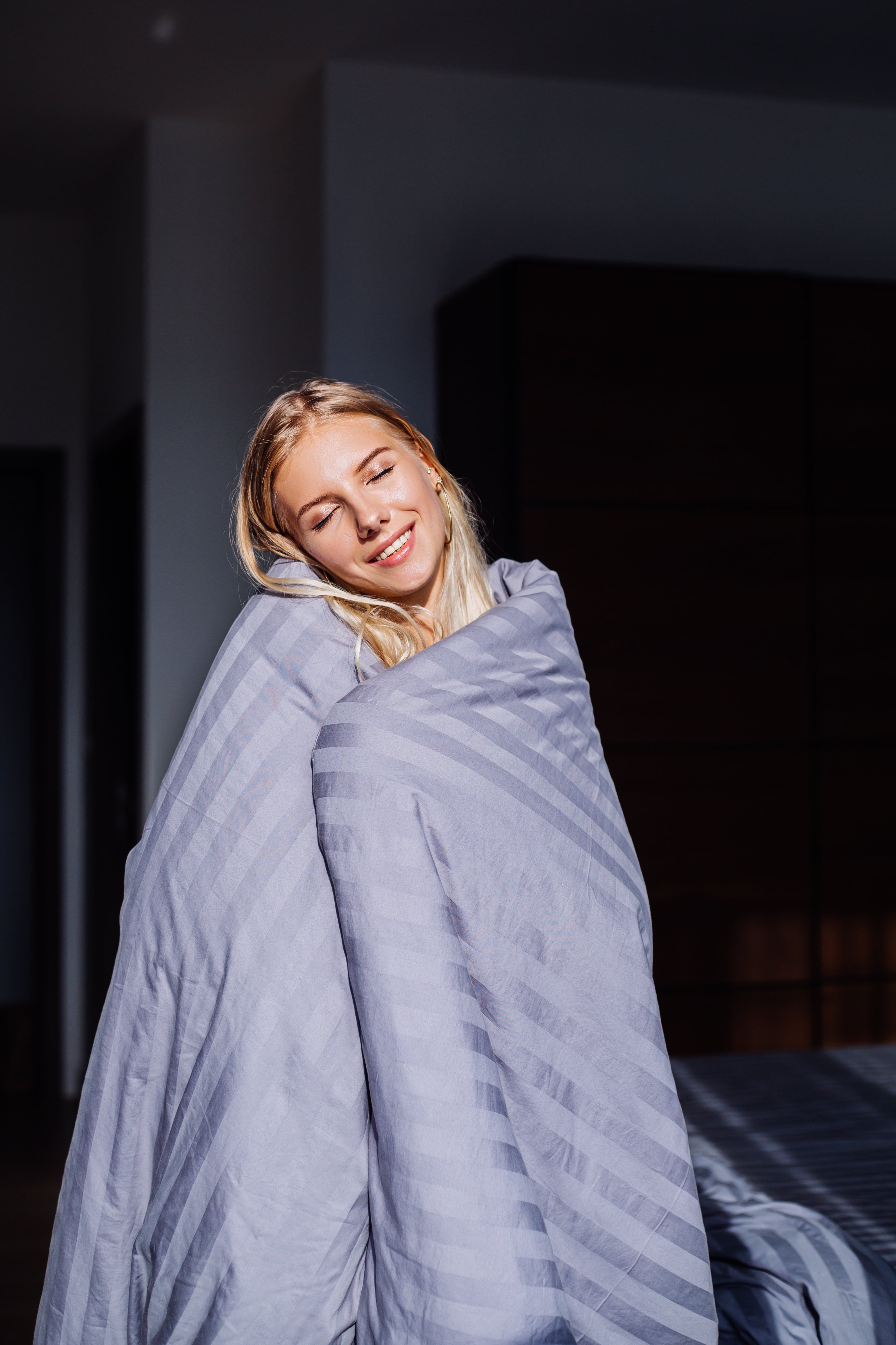 Portrait femme heureuse sous une couverture lestée